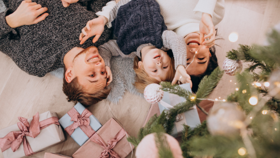 family lying under christmas tree