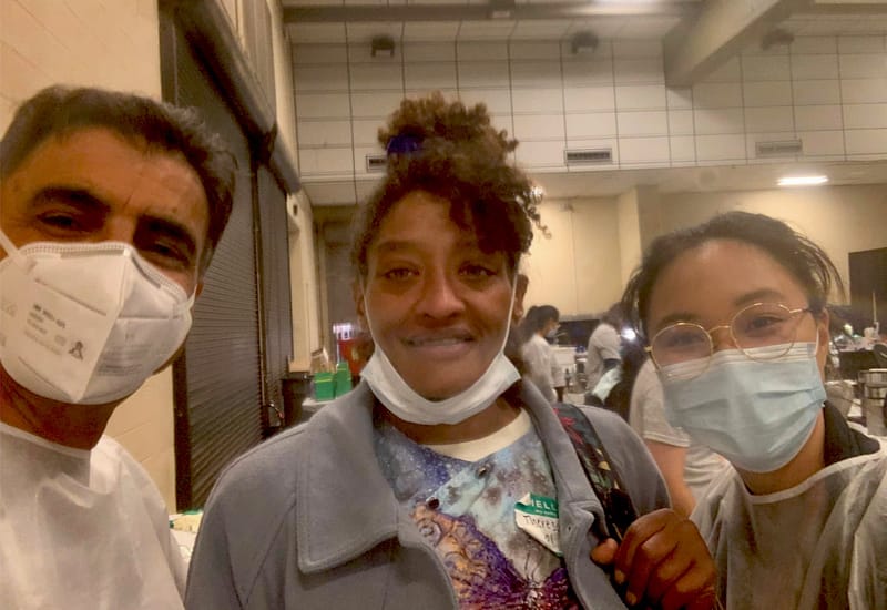 Dentists at a charity event where they help fix teeth for economically disadvantaged persons - With patient who looks happy.